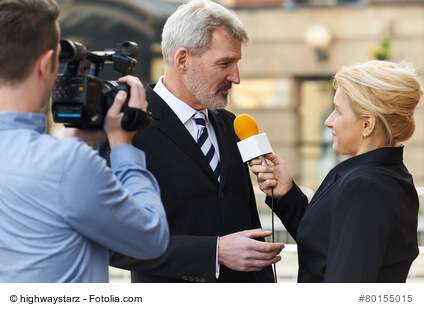 Female Journalist With Microphone Interviewing Businessman